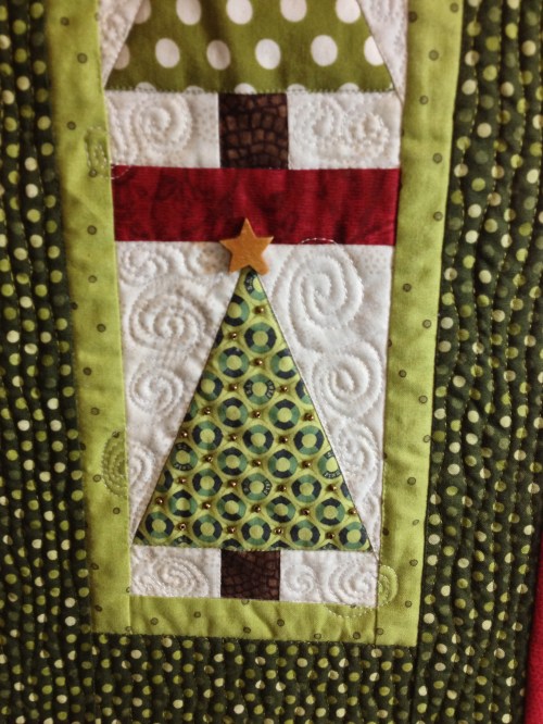 Quilting detail and wooden star bead embellishment.
